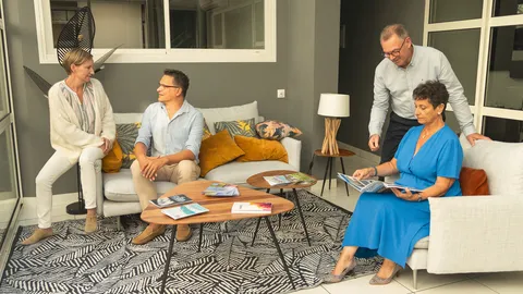 Conseillers de l’agence CISN Immobilier de Saint-Nazaire réunis dans l’espace d’accueil, consultant des brochures de logements neufs et de biens à vendre en Loire-Atlantique